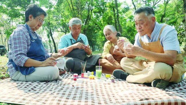 Group asian elderly people join recreation together to do activities and show their talents holiday in the park creative ideas designs paint colorful plaster relax make you feel good and healthy.