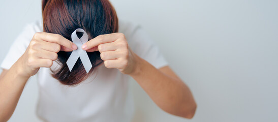 Woman having Headache with grey ribbon. Brain Cancer Awareness May month, World Brain Tumor day,...