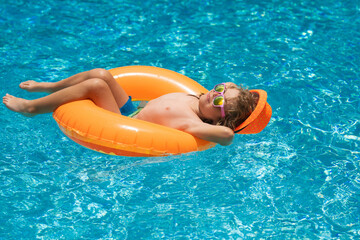 Child boy splashing in swimming pool. Swim water sport activity on summer vacation with children.