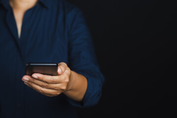 Smartphone in the hand of a businessman against a black background.