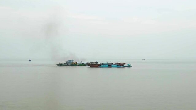 Drone shot of cargo ship emitting smoke and polluting Indian ocean in Bangladesh. Aerial