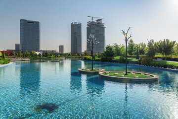 Contemporary buildings reflected in pool of Tashkent City Park - 772727985