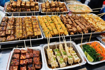 Obraz premium Street Food Snacks Items like stinky tofu, skewered meats (such as lamb kebabs or chicken skewers), Jianbing (Chinese crepes)