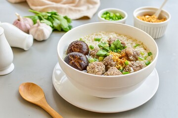Rice porridge with minced pork and shiitake mushrooms on white bowl, thai cusine 