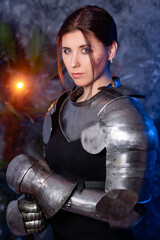 Portrait of a young woman with scars on her face, dressed in black clothes with steel knightly...