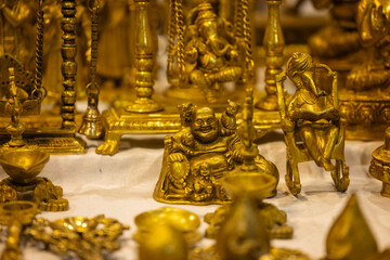 Brass metal art, Handmade laughing buddha sculpture souvenir made with brass with blur background. Selective focus.