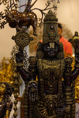 Fototapeta premium Brass metal art, Handmade Indian Lord Tirupati Balaji sculpture souvenir made with brass with plain background. Selective focus.