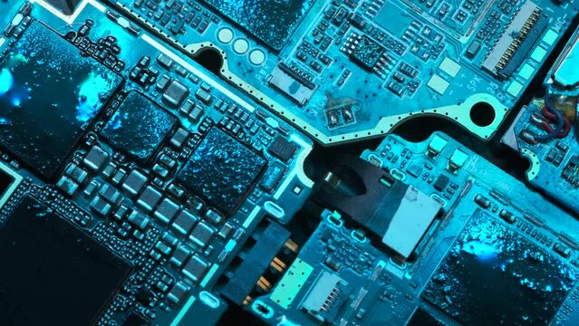 Motherboard from laptop, PC chip, cpu, circuits, computer components macro close up background in blue neon lights, tracking shot.