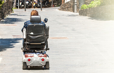 Woman in a electric wheelchair in the street with copy space