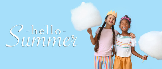 Cute little girls with cotton candy on blue background