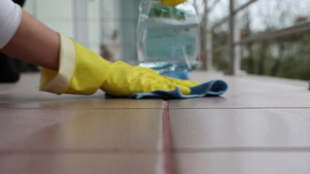 Woman cleaning tile floors outdoors, spring cleaning, 4k footage, home cleaning