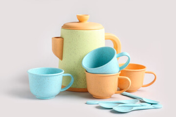 Teapot with cups and spoons on grey background. Children's Day celebration