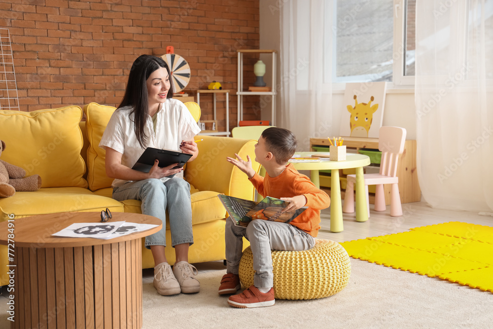 Canvas Prints female psychologist with little boy reading book in office