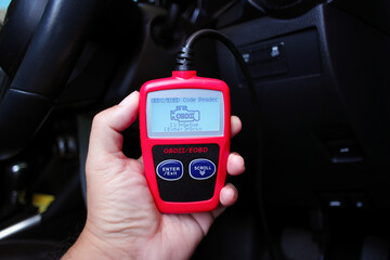 OBD2 or OBD scanner in a auto mechanic hand for engine system analysis , Car maintenance concept