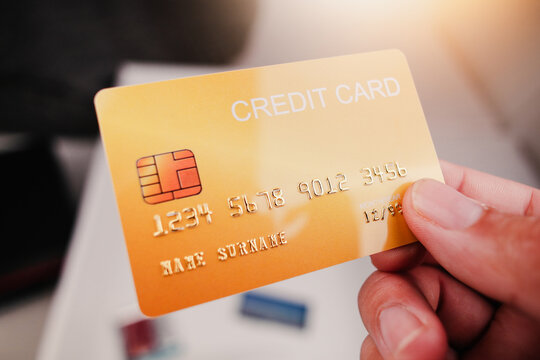 Mockup of yellow credit card in hand with sunlight , Credit or debit card financial concept