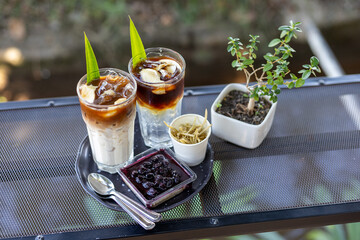 Iced coffee mixed with milk in a clear glass Coffee mixed with coconut water and coconut meat,...