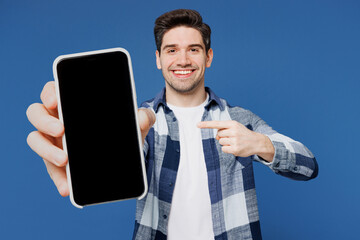 Young Caucasian man wear shirt white t-shirt casual clothes hold in hand use point index finger on mobile cell phone with blank screen area isolated on plain blue color background. Lifestyle concept. - 772795739