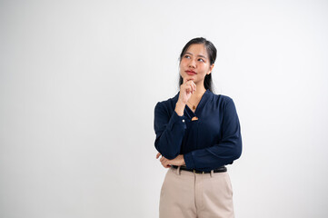 Creative Asian woman is showing a thinking expression gesture, with her hand on her chin, looking up