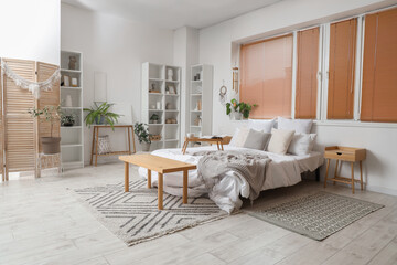 Interior of light bedroom with wind chime, dream catcher and plants