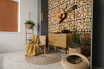 Interior of living room with wind chime, guitar and glucophone on drawers