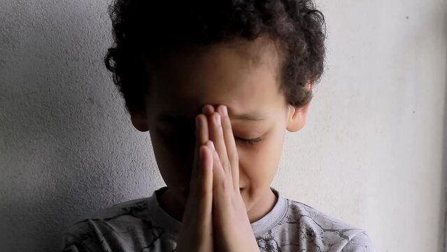 boy praying to God with hands held together with people sock footage stock video
