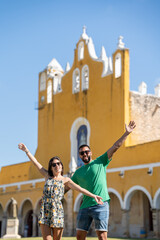 Young tourist couple with sunglasses at the Izamal convent enjoying the visit in Mexico.