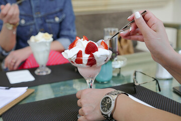 Person Eating Dessert With Strawberries and Whipped Cream