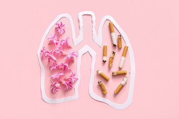 Paper lungs with flowers and cigarette butts on pink background. Stop smoking concept.