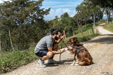 adult mixed-breed man training his border collie dog by teaching him how to shake hands