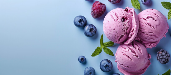 An appetizing trio of vibrant pink ice cream scoops surrounded by fresh berries and mint leaves