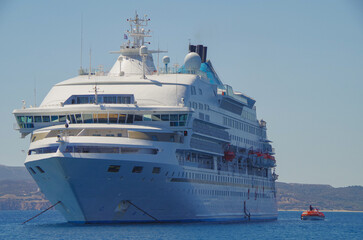 Small classic luxury cruiseship cruise ship liner yacht anchoring on Aegean blue sea in front of Milos Island during summer Mediterranean Greek isles cruising
