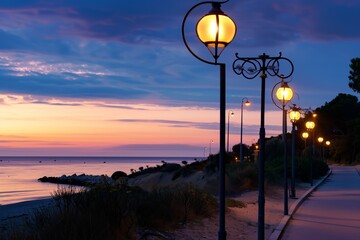 street lanterns illuminating a beachfront path at dusk