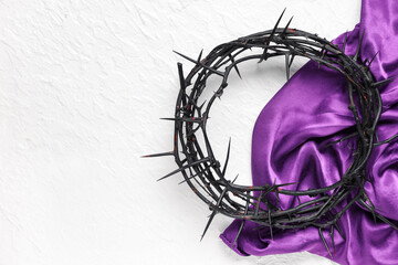 Crown of thorns with purple cloth on white grunge background. Good Friday concept