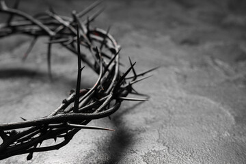 Crown of thorns on black grunge background, closeup. Good Friday concept