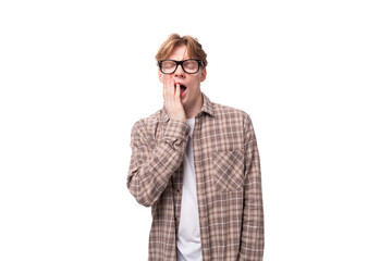 young charming student guy with red hair in glasses on a white background