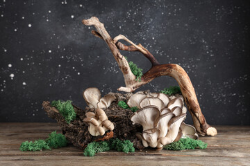 Tree branches with fresh oyster mushrooms and moss on wooden table