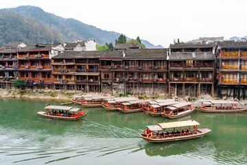 Feng Huang Ancient Town (Phoenix Ancient Town) and tourist boats on Tuo Jiang River, The famous tourist destination at Hunan Province, China - 772831718
