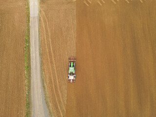 View from above of a tractor plow and sows the farm field