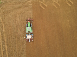 View from above of a tractor plow and sows the farmland