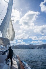 sailor sailing a yacht with a sail on a beautiful day exploring the australian coastline of tasmania