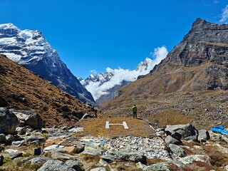 Person near a helicopter pad in the Himalayas with mountains in background