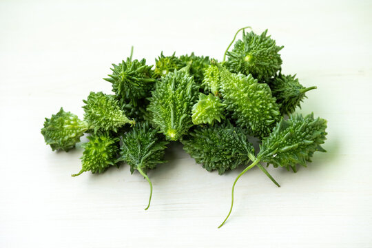 Bunch of fresh bitter melon on white background. Its scientific name is Momordica charantia. It is also known as bitter gourd, balsam pear, korola, korolla, karela.