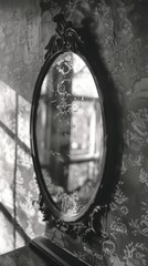 Vintage oval mirror in an ornate frame against a patterned wallpaper