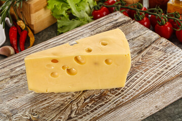 Swiss Maasdam cheese triangle over board