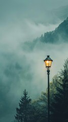Illuminated street lamp against a foggy mountain landscape