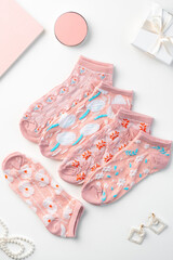 Pastel composition with pink socks on white background