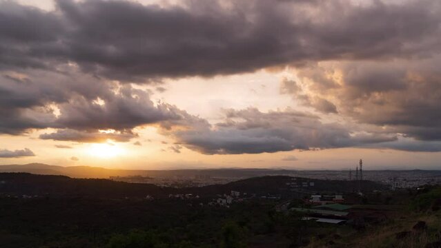 Timelapse of sunset over a city during golden hour with dramatic clouds in the background. Shot in 4K ultra HD smoothest and clearest video.