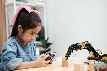 A young girl is playing with a remote control a robot