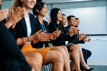  Professional young Asian and Caucasian audience applauding in group meeting presentation from partnership at office. Businessmen and businesswomen celebrating great success achievement. uds © Summit Art Creations
