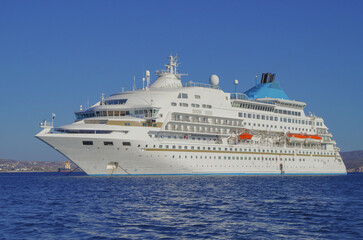 Small classic luxury cruiseship cruise ship liner yacht anchoring on Aegean blue sea in front of Milos Island during summer Mediterranean Greek isles cruising